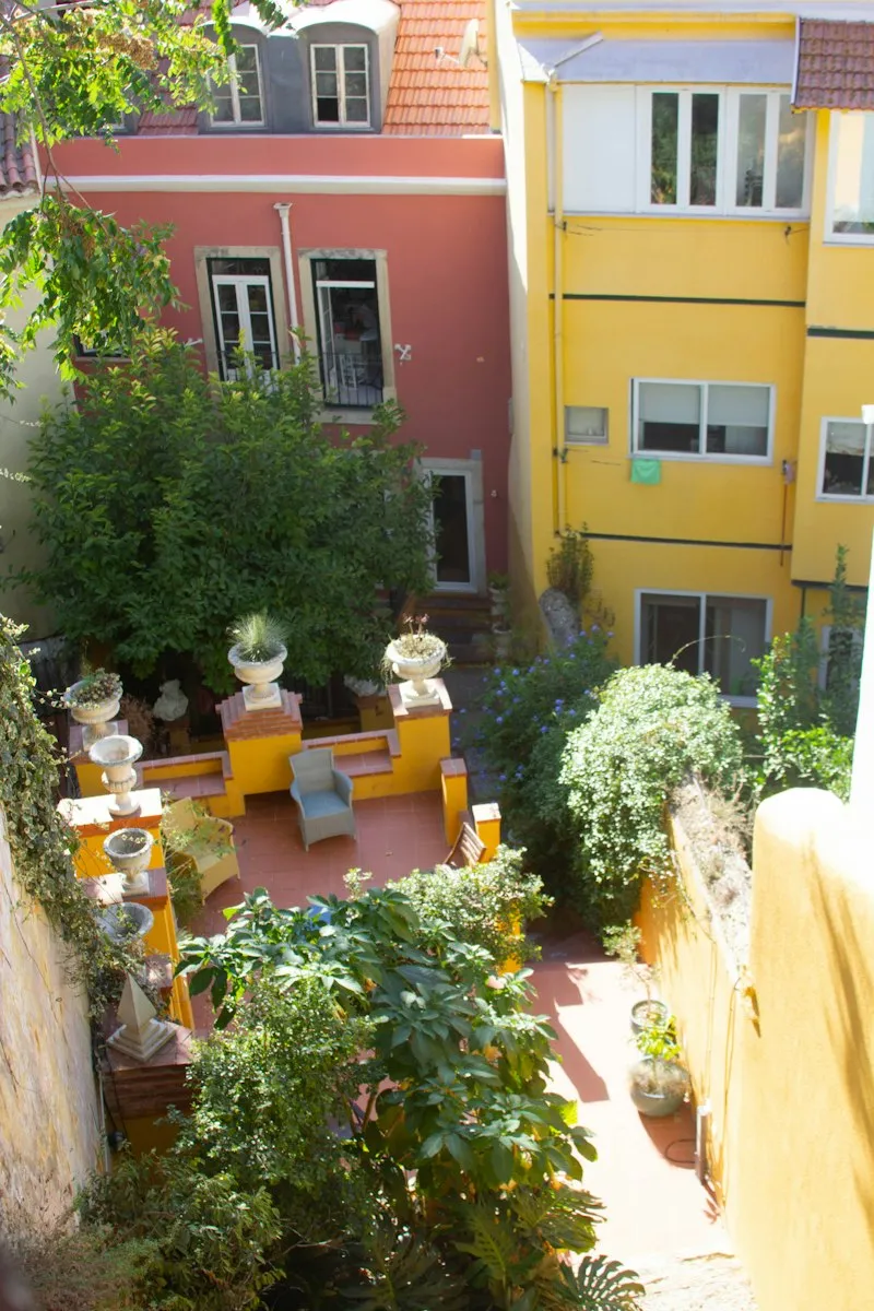 Une cour de Lisbonne avec des plantes et des façades anciennes